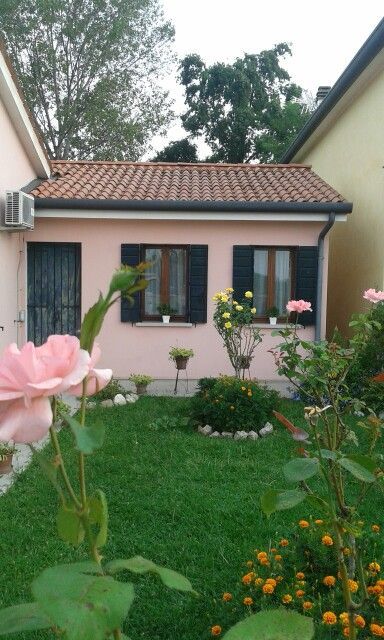 a pink house with flowers in the front yard