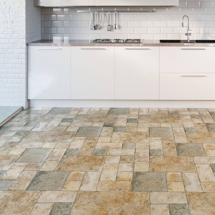 a kitchen with white cabinets and tile flooring