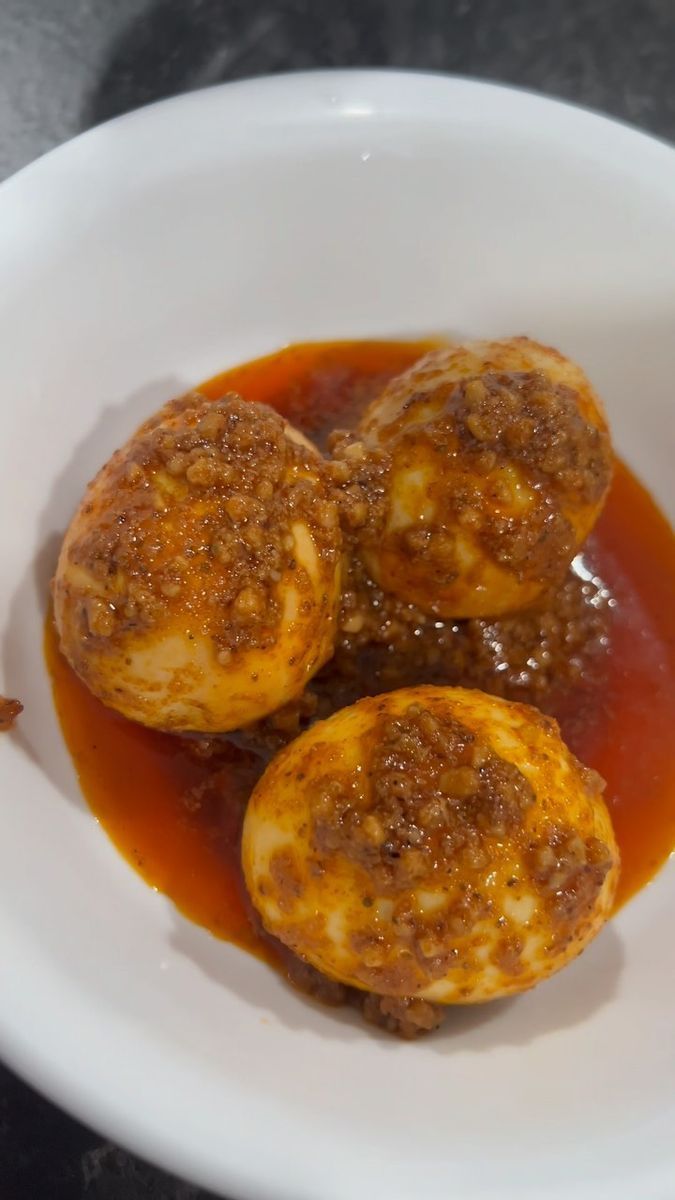 some food is in a white bowl on a black counter top and it looks like they have been cooked