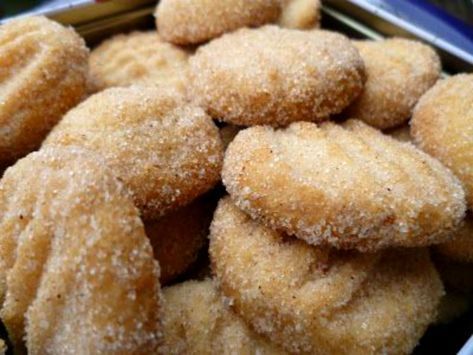 some sugared donuts are in a metal container