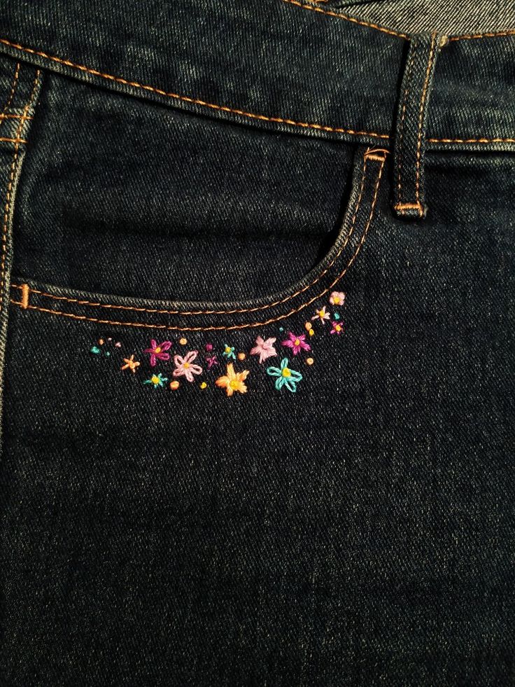 a pair of jeans with colorful embroidered flowers on them