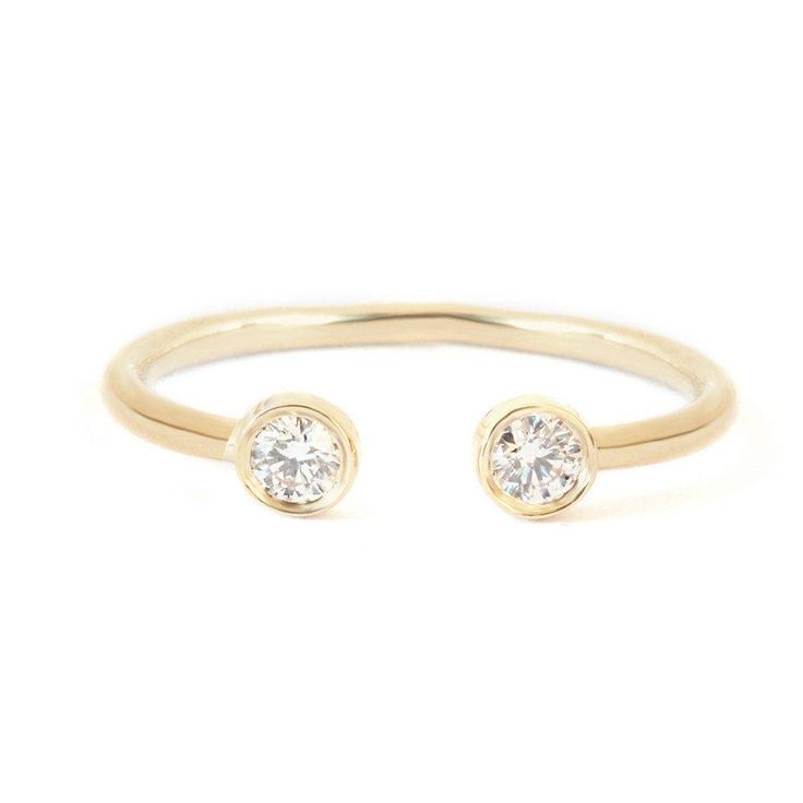 a gold ring with two diamonds on it