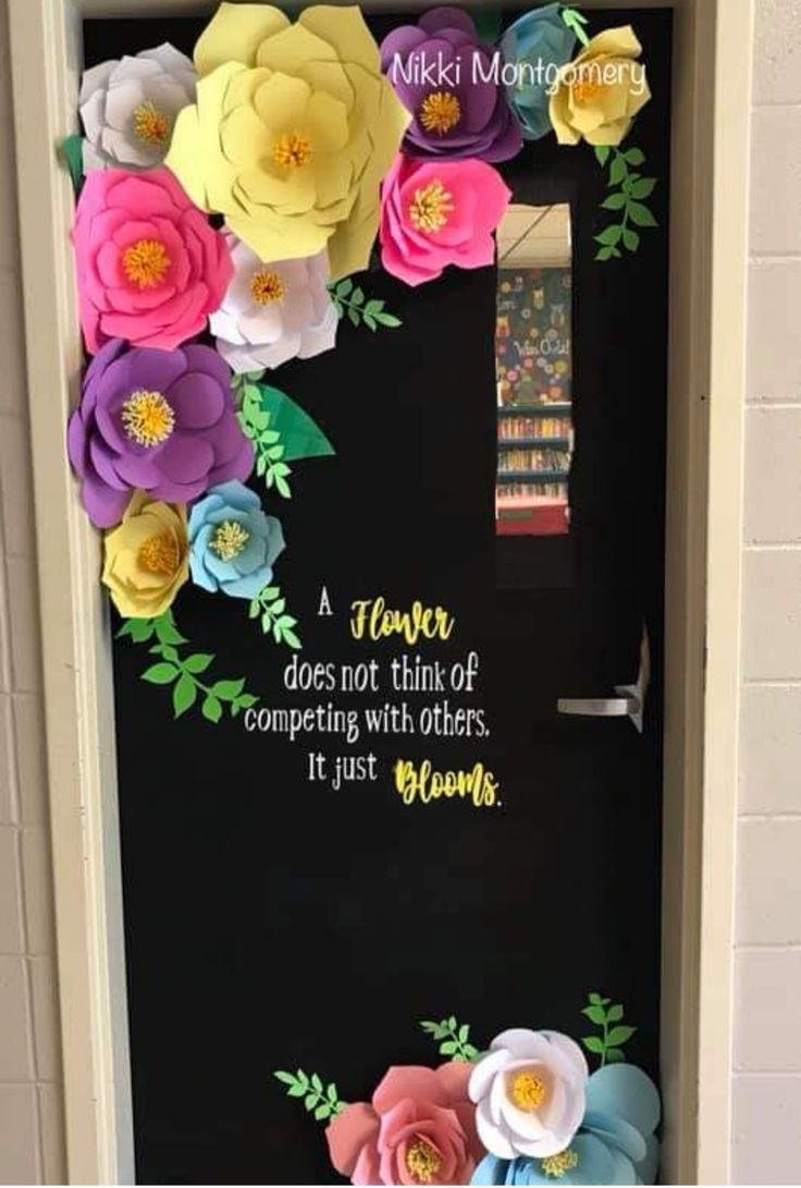 a door decorated with paper flowers and a quote