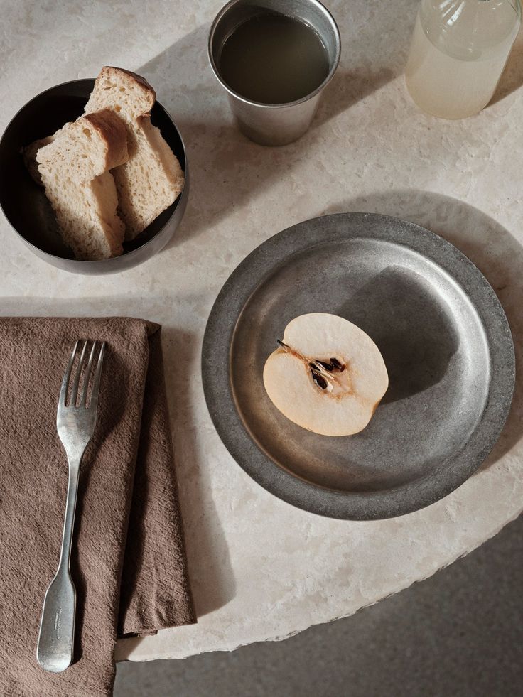 an apple slice is on a plate next to some silverware