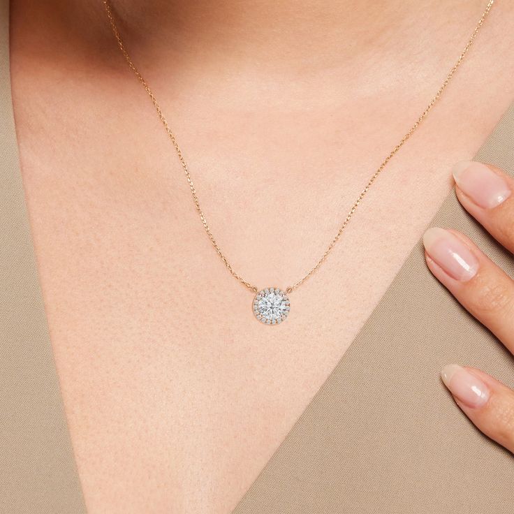 That one piece that will inject a shot of glamour into your looks. This white gold necklace features round diamond surrounded by a halo of smaller round diamonds. Four prongs secure the center diamond in place. The timeless look of this necklace allows you to pair it with almost any of your favorite outfits. Dazzling Solitaire Necklace With Round Pendant And Halo Setting, Dazzling Solitaire Necklace With Halo Setting, Dazzling Round Pendant Solitaire Necklace With Halo Setting, White Round Halo Necklace, Dazzling Round Diamond Necklace With Halo Design, Dazzling Round Pendant Diamond Necklace With Halo Design, Dazzling Diamond Necklace With Halo Design And Round Pendant, Diamond White Round Halo Necklace, Diamond White Halo Round Necklace