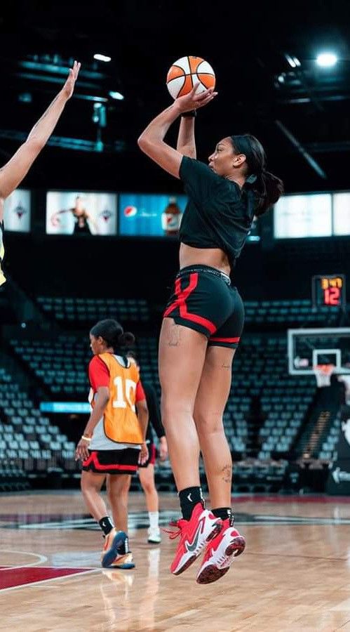 two women are playing basketball on the court