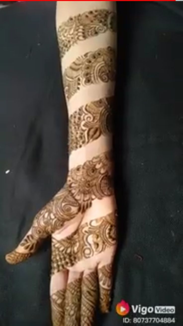 a woman's hand with henna tattoos on it