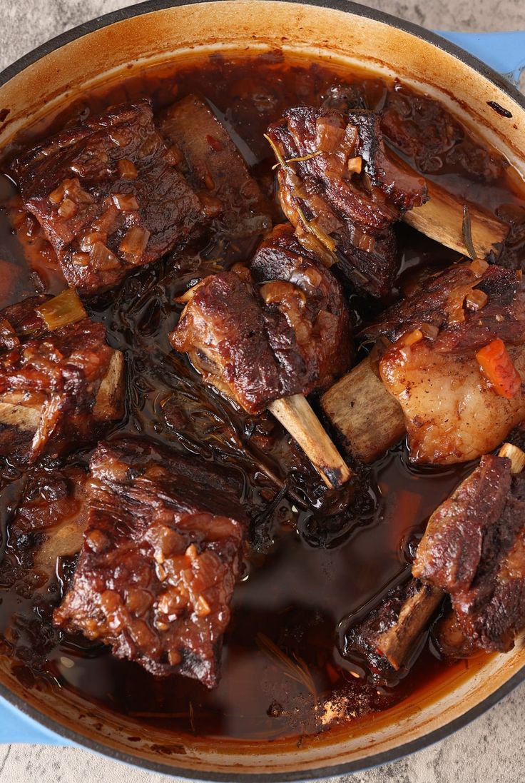 a pot filled with meat and vegetables on top of a table