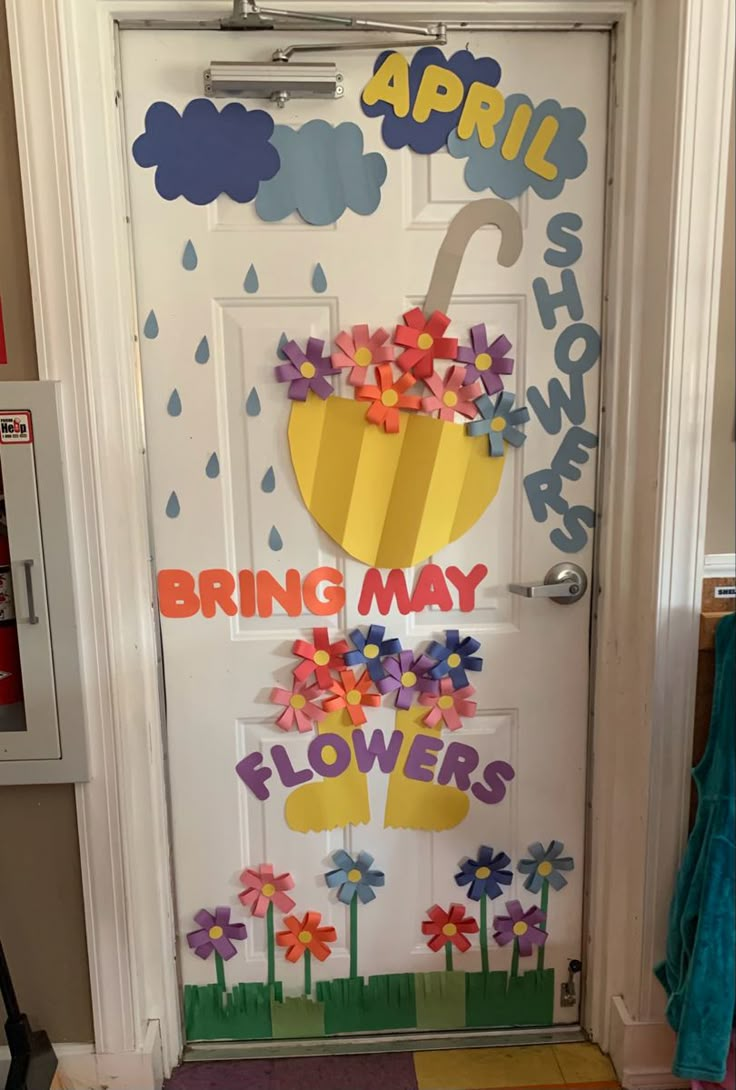 a door decorated with paper flowers and an umbrella for the month of march on it