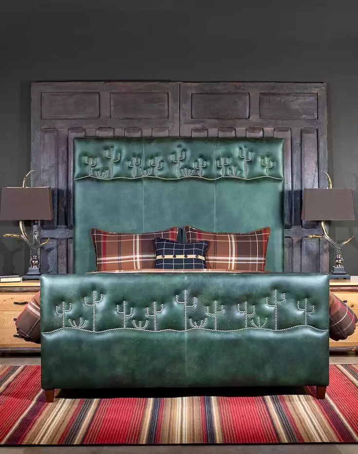 a green leather bed sitting on top of a rug next to a wooden headboard