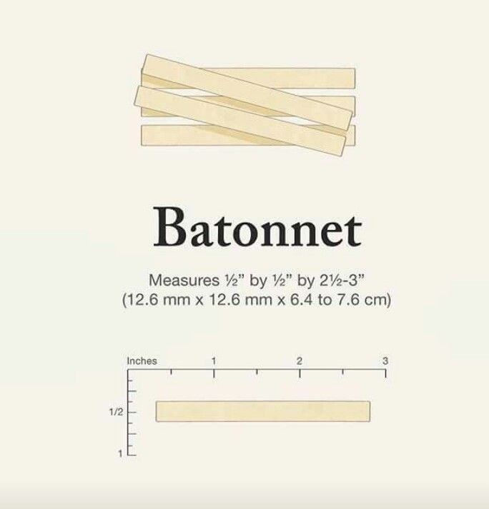 a bunch of wooden strips sitting on top of a white table next to a ruler