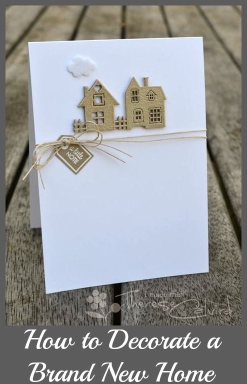 a white card with brown paper houses on it and a tag hanging from the front