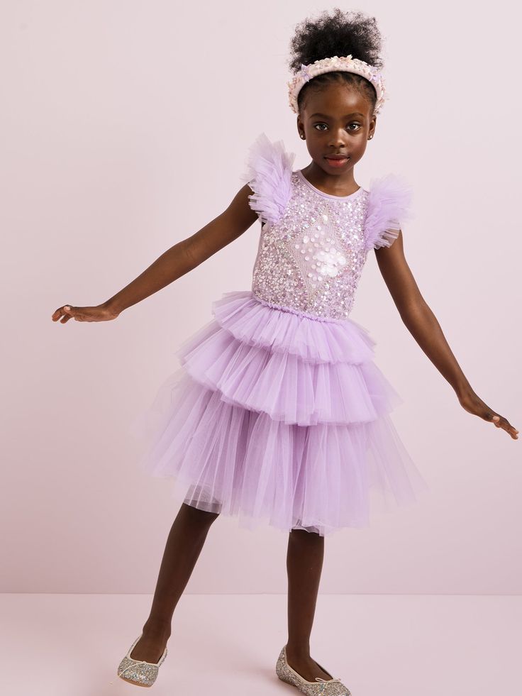 The Mirror Ball Tutu Dress in Lilac Thistle embodies ethereal elegance and makes a bold statement. Hand-applied sequins adorn this enchanting dress, creating a dazzling display of shimmer and shine. With a tiered skirt that adds movement and flair, and a diamond-shaped sequin design on the bodice, this dress exudes sophistication and charm. It's truly a vision in purple, perfect for any special occasion where your little one wants to stand out and shine bright. This style is also available in Be Purple Girls Dress, Tiered Tulle Skirt, Designer Dresses For Kids, Toddler Girl Outfit, Eid Dresses, Sequin Design, Mirror Ball, Shimmer And Shine, Costume Collection