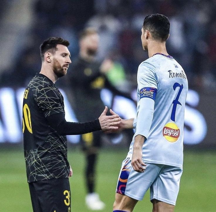 two soccer players are shaking hands on the field