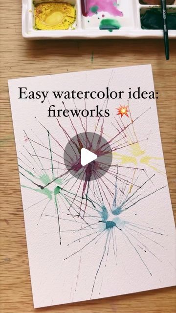 an easy watercolor idea fireworks card is displayed on a table next to paintbrushes