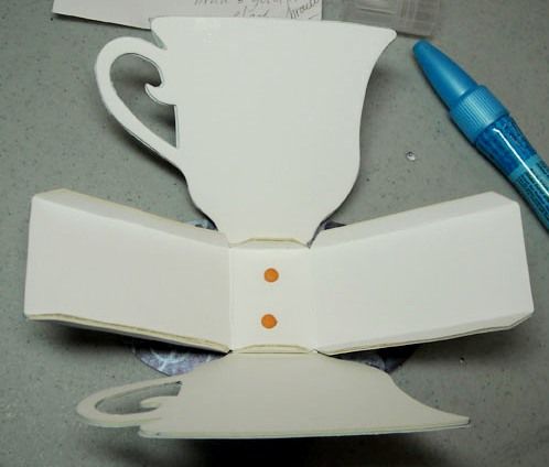 a cup and saucer sitting on top of a counter next to a marker pen