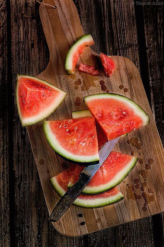 slices of watermelon on a cutting board with a knife