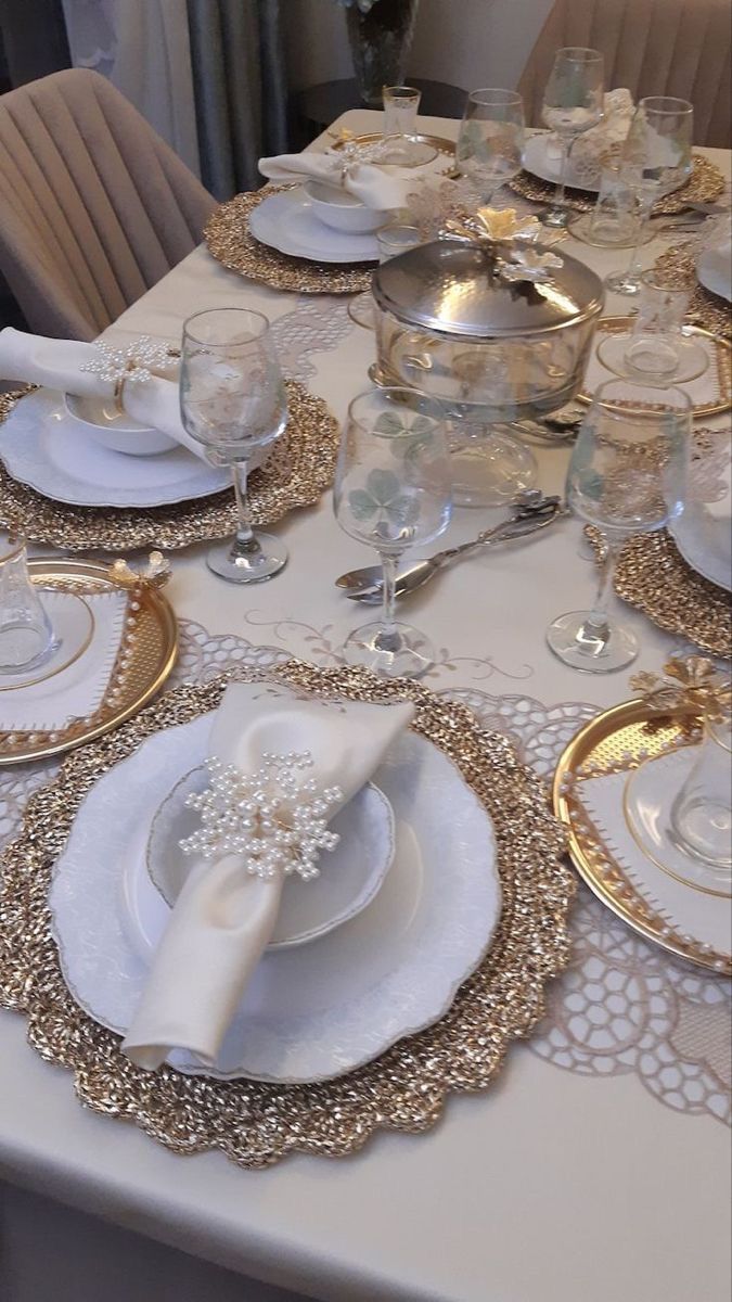 the table is set with white and gold dishes