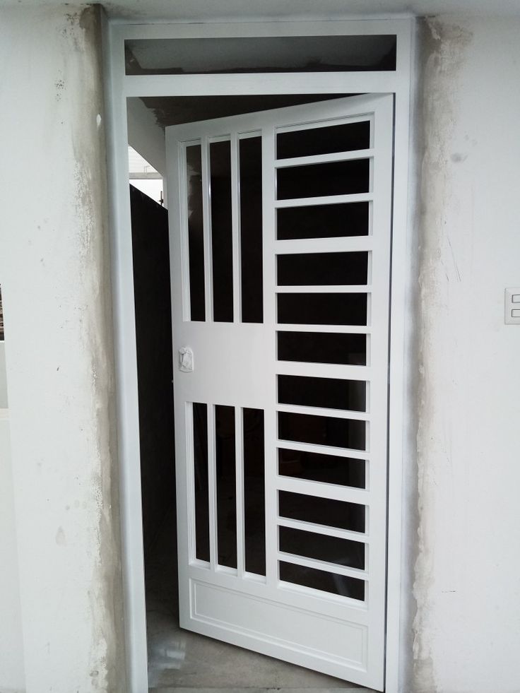 an open white door with bars on the outside and inside doors are painted in black