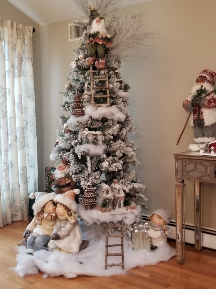 a small christmas tree in the corner of a room with snow on it and other decorations