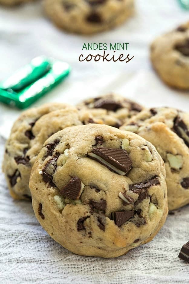 chocolate chip cookies and mint green toothbrush on white table cloth next to dental floss