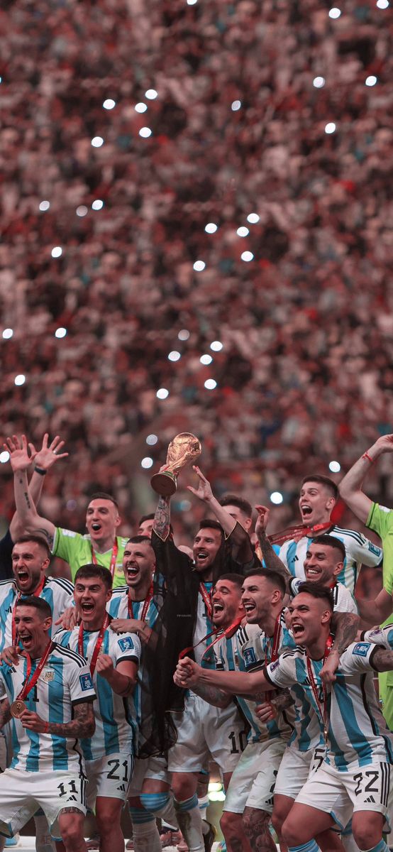 a group of men standing next to each other in front of a crowd holding up a trophy