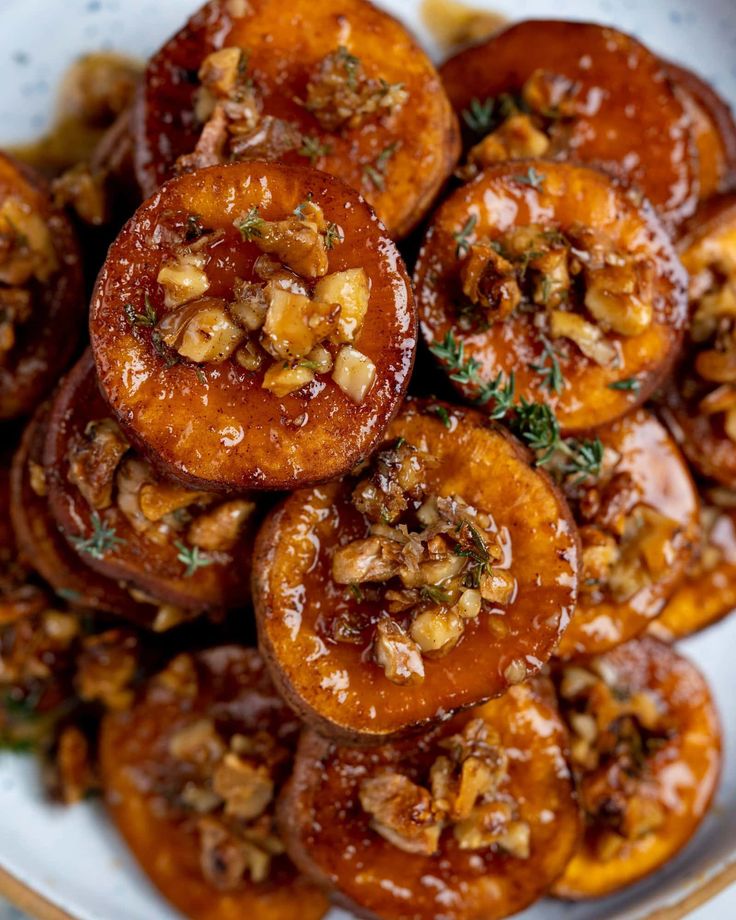 a white plate topped with sweet potatoes covered in nuts