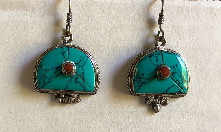 This pure silver, turquoise and coral earrings are handmade in Nepal. It is traditional Tibetan jewelry and it has double Vajra on the back. Traditional Turquoise Drop Earrings, Traditional Turquoise Sterling Silver Earrings, Traditional Turquoise Earrings As A Gift, Traditional Earrings With Natural Stones For Gifts, Traditional Sterling Silver Earrings With Natural Stones, Traditional Turquoise Earrings With Natural Stones, Traditional Red Earrings With Natural Stones, Traditional Round Earrings With Natural Stones, Tibetan Jewelry