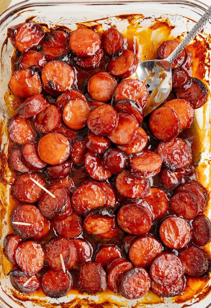 a casserole dish filled with cooked sausages and sauce, ready to be eaten