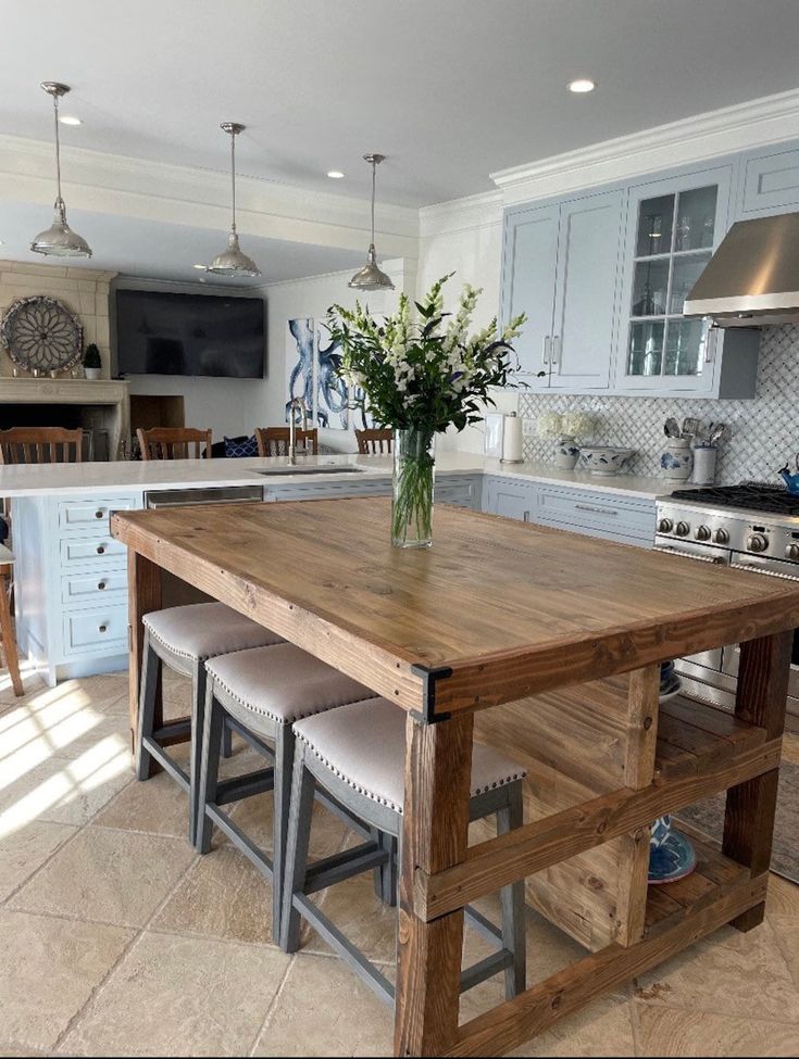 a kitchen island with stools in front of it and a vase on the counter