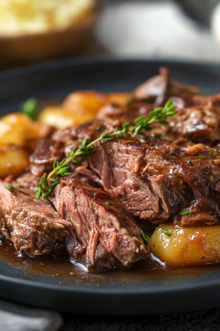 a close up of a plate of food with meat and potatoes