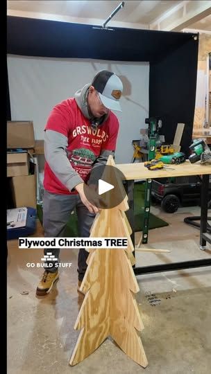 a man working on a wooden christmas tree