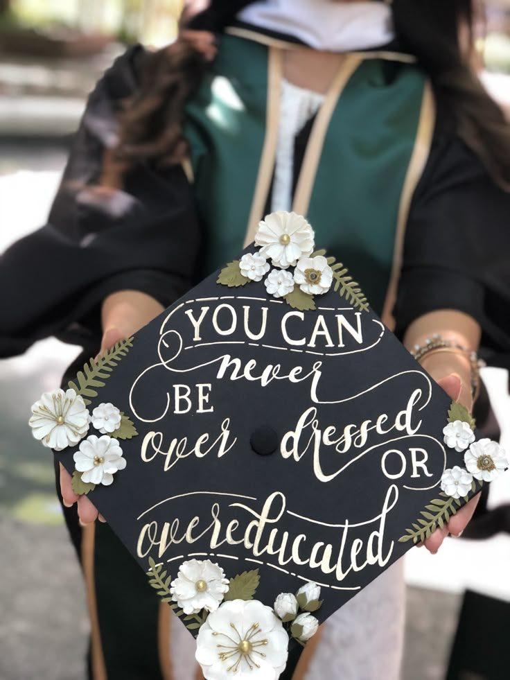 a woman holding a graduation cap with flowers on it