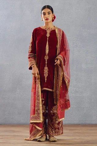 Bright red kurta with gold thread and sequin embroidered motifs. Comes with phiran and silk organza dupatta.
Component: 3
Pattern: Embroidery
Type Of Work: Thread, Gota Patti and Sequin
Neckline: Round
Sleeve Type: Full
Fabric: Silk Velvet, Cotton Voile and Silk Organza
Color: Red
Other Details: 
Dupatta with gota patti border and fringe detail
Side slits
Low back with tie and tassels
Phiran with embroidered hem
Occasion: Wedding - Aza Fashions Luxury Raw Silk Dabka Embroidered Sets, Luxury Art Silk Salwar Kameez With Zari Work, Luxury Art Silk Churidar With Dori Work, Luxury Katan Silk Unstitched Suit For Puja, Luxury Dola Silk Salwar Kameez With Cutdana, Luxury Red Churidar With Cutdana Details, Luxury Red Unstitched Salwar Kameez, Luxury Red Georgette Unstitched Suit, Luxury Multicolor Salwar Kameez With Dori Work