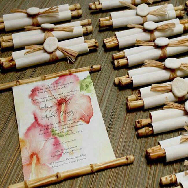 a table topped with lots of white and pink flowers on top of wooden pegs