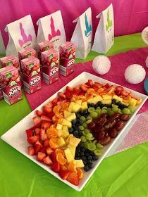 there is a platter of fruit on the table with bags of juice in the background