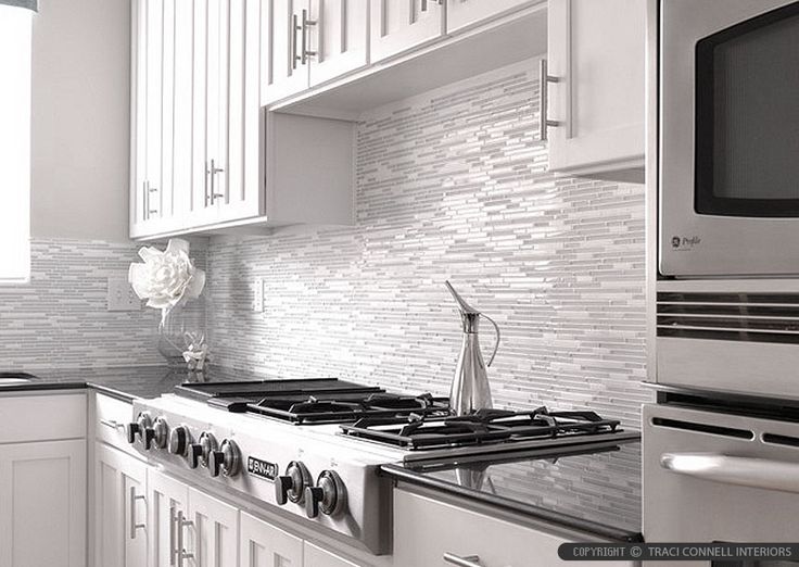 black and white photograph of a kitchen with stove, oven, microwave and counter tops