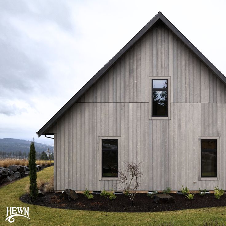 a house that is made out of wood and has two windows on the side of it