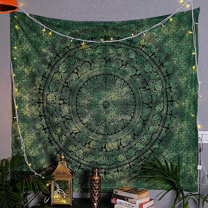 a green tapestry hanging on the wall next to a lamp and some potted plants