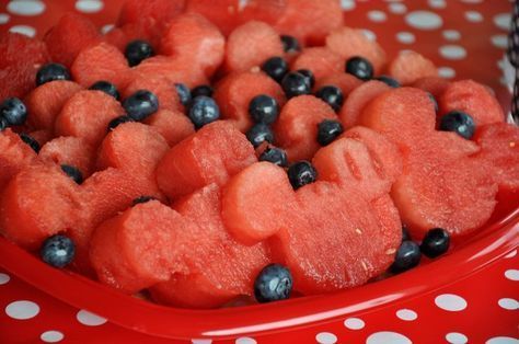 watermelon and blueberries in a red bowl on a polka dot tablecloth