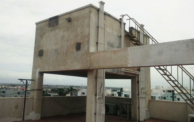 an unfinished building with stairs leading up to the top floor and another structure in the background