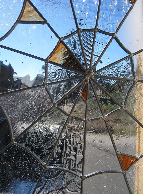 an old broken glass window with water drops on it and the reflection of a building