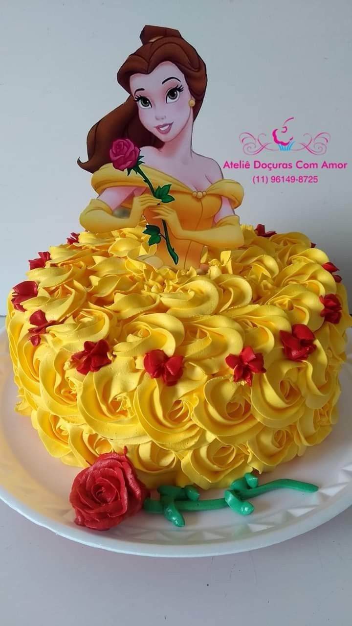 the cake is decorated with yellow icing and red roses on it's side