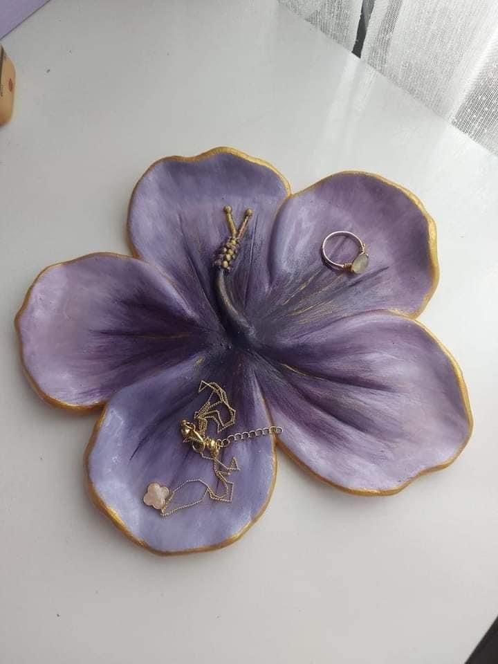 a purple flower with two gold rings on it's middle and one ring in the middle