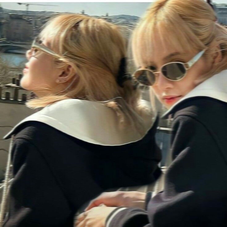 two women in black jackets and sunglasses standing next to each other