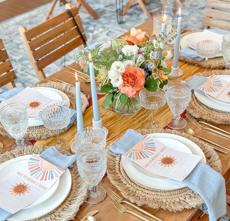 the table is set with place settings and flowers in glass vases on top of burlocks