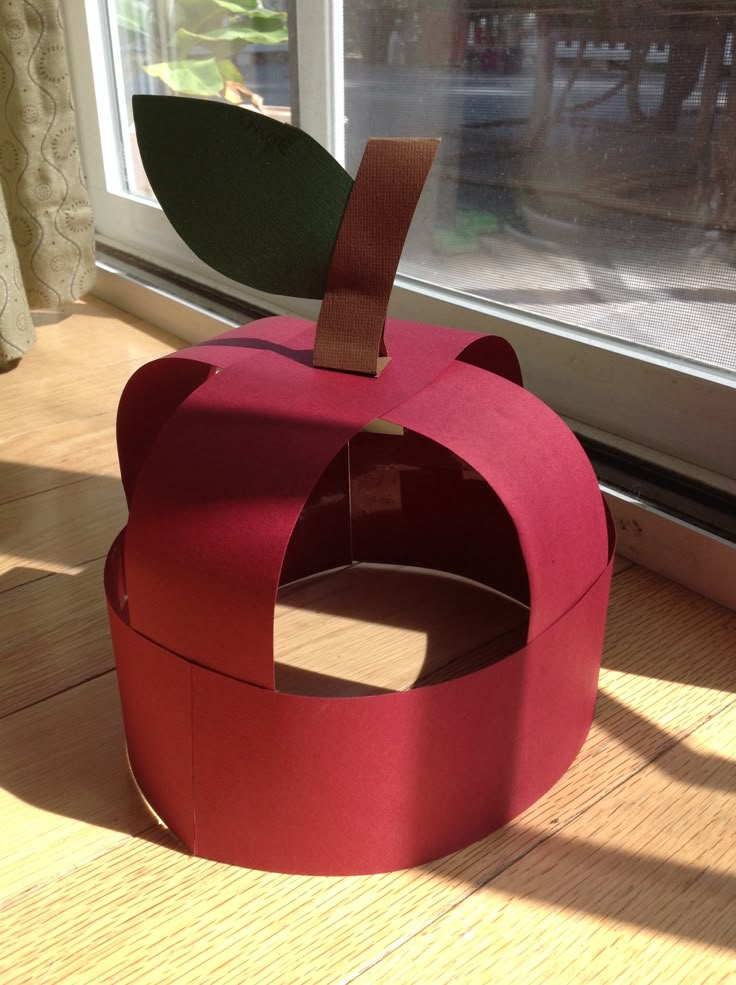 an apple shaped box sitting on top of a wooden floor