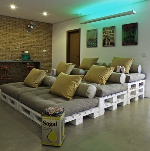 a room with couches made out of pallets and some yellow pillows on them