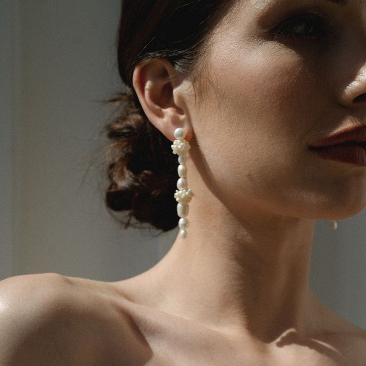 Our gorgeous Amelie Pearl Drop Earrings are hand assembled with freshwater pearls to create an undeniably elegant, minimal, and modern vibe. Perfect for any bridal affair, these asymmetrical earrings make for a tasteful and modern look. With its organic pearls, the Amelie Pearl Drop Earrings will give you a timeless and minimal style fit for all of your special occasions. Gold plate over brass Freshwater pearl fringe accents Hand-crafted and assembled Lightweight 1.5" in length Nickel- and lead- Delicate Pearl Chain Earrings, Feminine Pearl Earrings For Evening, Modern White Pearl Earrings, Feminine Evening Pearl Earrings, Graceful Pearl Earrings With Pearl Charm, Graceful Pearl White Pearl Earrings, Modern White Akoya Pearl Earrings, Pearl White Pearl Drop Linear Earrings, Pearl White Linear Pearl Drop Earrings