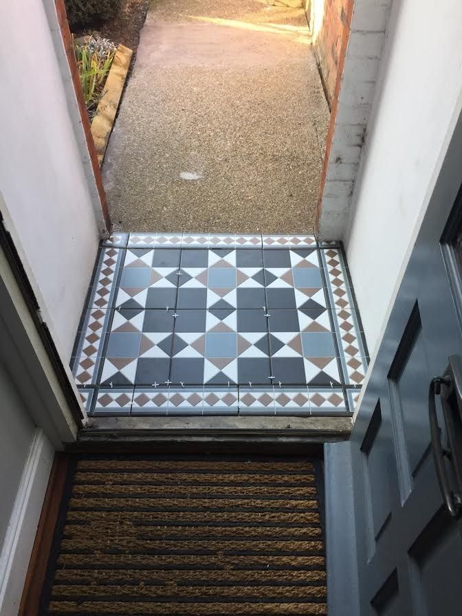 an open door leading to a tiled walkway